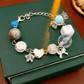 Detalle de pulsera de cuentas con colgantes de caramelos, estrellas y corazones - Azul