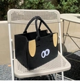 Dettaglio di una borsa in feltro nero con design animale carino su una sedia in metallo - Stile Cane con Occhiali / Nero