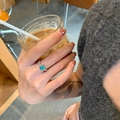 Elegant silver open ring featuring an oval teal gemstone shown on a model hand - Silver Oval Blue-Green Gemstone Ring (J5727)
