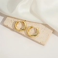 Dettagli di orecchini a cerchio dorati a forma di C su pietra beige e seta bianca - Cerchio (Grande)