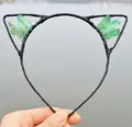 Detail view of handmade cat ear headband with green raw crystals and black metal frame - No.27 Bright Green