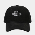 Close-up of white embroidery text on black corduroy texture of the baseball cap - One Size / Black