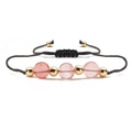 Handmade woven bracelet with pink natural stone beads and golden accents on white background - Watermelon Pink