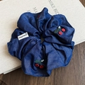 Detail van een donkerblauwe denim scrunchie met kersenborduurwerk, parels en happiness tag - Grote Scrunchie - Donkerblauw - Kers Borduurwerk