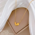 Dettaglio della collana con pendente a foglia dorata e specifiche su sfondo di seta bianca - Oro (T330 Oro)