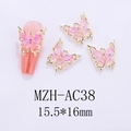Detailed view of pink iridescent butterfly nail charms with gold frames on white background - Gold Frame Pink Gradient (AC38)