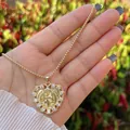 Vista ravvicinata della collana a cuore placcata oro 18K con zirconi e rilievo religioso - Cuore San Benedetto