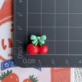 Mini resin red cherry with green bow detail shown next to a ruler for size measurement - Cherry with Green Plaid Bow