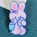 Cute pink cartoon rabbit acrylic brooch featuring a bunny with blue bow on teal fabric - Phone-Watching Rabbit