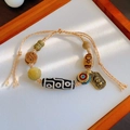 Ethnic style woven bracelet with Dzi bead agate and a metallic relief charm - God of Wealth Plate: Dzi Bracelet
