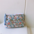 Detail of floral cotton mini pouch featuring a secure zipper and light blue woven tassel cord - Pink Green Floral