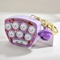 Detail of a purple mini whack-a-mole toy keychain with a bell on a display block - Light Gold Buckle + Mole Machine Bell / Purple