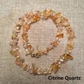 Close-up of irregular natural citrine crystal stone necklace with a gold metal clasp - Citrine