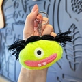 Neongrüner Plüsch Monster Schlüsselanhänger mit schwarzen Zöpfen und Metallring - Geflochtenes Monster / Grün