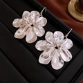Macro shot of silver metallic flower earrings with textured petals on a black tray - 29# Silver Large Hollow Flower (Ear Hook)