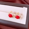 Vista macro di orecchini a triangolo placcati in oro 18k con perle rosse e cristalli - Stile Perla Rossa Triangolo Cavo / Oro