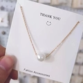 Elegante gouden titanium ketting met een enkele ronde witte parelhanger op kaart - Stijl met enkele parelhanger / Roségouden parelketting