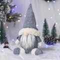 Grey Christmas gnome plush with tall hat and white beard on a festive winter background - Gray Sitting Doll