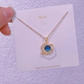 Détail macro du pendentif planète dorée avec croissant de lune et pierres bleues fines - Planète Croissant de Lune (XK0039)