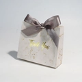 Detail of marble pattern gift box with golden Thank You text and grey ribbon bow - Gray