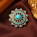 Makro-Detail der Vintage-Brosche mit blauen Türkisen auf braunem Seidenstoff - Künstliche Türkis Scheibe-Türkisblau