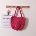 Handmade crochet cotton tote bag in vibrant rose red hanging on a minimalist wall hook - Rose Red