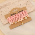 Detailed view of pink Bohemian beaded bracelets layered on a craft jewelry card - Pink