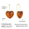 Détail de boucles d'oreilles cœur en résine ambre avec crochets dorés et dimensions - Marron