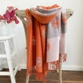 Detail of soft orange and grey camellia pattern shawl with tassels on a vintage chair - Dandelion Orange