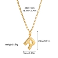 Macro detail of golden letter R pendant on paperclip chain with size annotations - Letter R