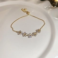 Primer plano de pulsera de flores doradas con circonitas brillantes en plato blanco - 2# Pulsera - Dorado (Bañado en Oro Real)