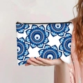 Detail einer Hand, die eine Kosmetiktasche mit blauem Evil-Eye-Muster und Reißverschluss hält - Blaues Mandala Geometrisch (jiaying0033)