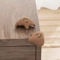Set of two brown silicone corner protectors with cute smile face for baby safety - Fluid-Coffee