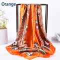 Detail eines orangen Frühlingsschals mit Paisley-Muster an einem schwarzen Metallständer - Orange