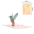 3D hummingbird pop-up card with intricate hollow designs on a pink floral background - Maple Leaf Bird