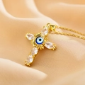 Makroaufnahme einer Goldkreuz-Halskette mit blauem Evil Eye und Kristallen auf Seide - Weiß