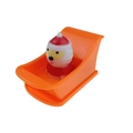 Wind-up clockwork Santa Claus toy in an orange plastic sleigh on a white background - Santa in Boat Orange