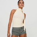 Chic beige halter neck tie-up top paired with slim fit grey shorts on a model - S / Off White