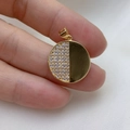 Gold plated circular pendant featuring half-paved zircons and half-polished metal surface - Round