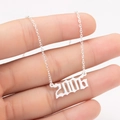 Detailed macro view of silver polished gothic style 2006 year pendant on a stainless steel chain - 2006 / Steel