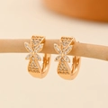 Close-up of champagne gold hoop earrings with zircon pavé on a wooden stand - EH216 Leaf Micro Pave