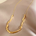 Elegante goldene Halskette mit quadratischen Gliedern auf luxuriösem Champagner-Seidenstoff - X949 Gold - Minimalistische Fluid-Metallkette