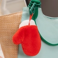 Detalle de un colgante de guante de peluche rojo y blanco en un bolso tejido con gancho verde - Gloves