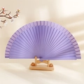Minimalist purple solid wood folding fan on a wooden display stand with floral accents - Purple