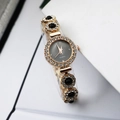 Close-up of golden jewelry watch with black chalcedony links and crystal accents - Black