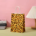 Close-up of leopard print paper gift bag with white twisted rope handles on a green desk - Leopard Print / H21*L15*W8CM