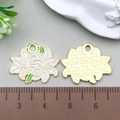 Macro detail of white lily flower charm showing enamel front and textured gold metal back - White Enamel Lily 17*20mm