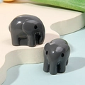 Detail of miniature dark grey resin elephant figurines on minimalist display stand - Grey Elephant