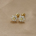 Détail macro de boucles d'oreilles marguerites avec zircons sur satin couleur champagne - Or-Blanc