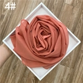 Detail eines orange-rosa Chiffonschals mit Goldglitzer in Form einer Rose gefaltet - Orangerosa